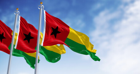 National flags of Guinea-Bissau waving in the wind on a clear day - obrazy, fototapety, plakaty