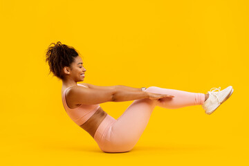 African american woman performing a pilates boat pose