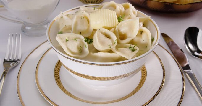 Dumplings in a plate with butter on the table, Uzbek Chuchvara - option 2