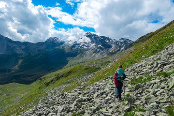Fototapeta na wymiar Hiker woman on extreme alpine terrain with scenic view of majestic mountain peak Vorder Geisslkopf, High Tauern National Park, Carinthia, Austria. Idyllic hiking trail remote Austrian Alps. Wanderlust