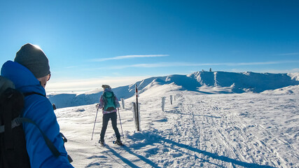 Couple in snowshoes on the way to majestic summit peak Grosser Speikogel in Kor Alps, Lavanttal...