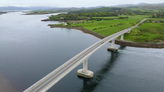 A drone shot of a car crossing a bridge along the Atlantic Coast. Harry Blayney Bridge, Mulroy, Co. Donegal, Ireland