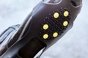 Overlay anti-slip spikes on soles of winter shoes to improve traction and prevent slipping during...
