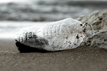 A Plastic water bottle waste washed up on the beach pollution - obrazy, fototapety, plakaty