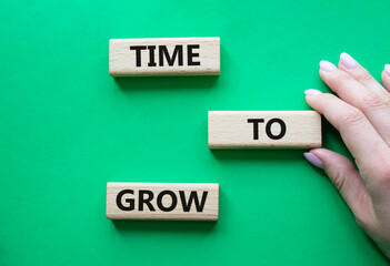 Time to Grow symbol. Concept word Time to Grow on wooden blocks. Businessman hand. Beautiful green...
