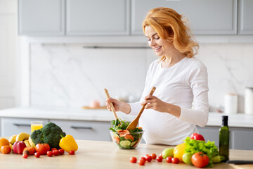 Obraz na płótnie Canvas Pregnant lady preparing salad at home