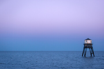 Lighthouse in the sea, Dovercourt low lighthouse at high tide built in 1863 and discontinued in 1917 and restored in 1980 the 8 meter lighthouse is still a iconic sight after sunset - obrazy, fototapety, plakaty