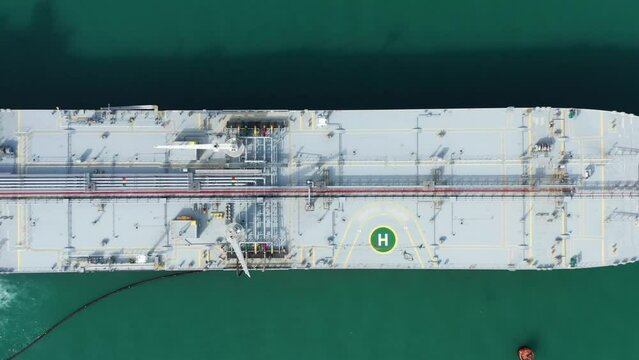 Tanker moored at oil terminal, intricate part of global petro resource trade, aerial view from drone. Key hub in industry logistics and distribution. Essential in the chain of energy supply and