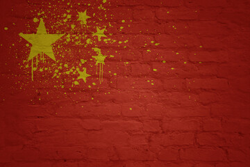 colorful painted national flag of china on a massive old brick wall