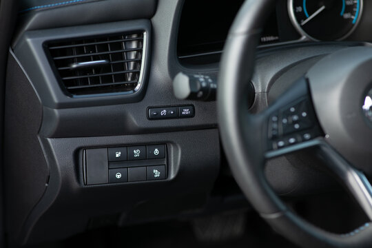 Cruise control, speed limit and volume buttons on modern car steering wheel, interior details. Buttons on the steering wheel. Electric car with adaptive cruise control radar