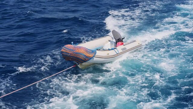 Floating lifeboat tied to pleasure yacht concept for rescue operations and maritime safety