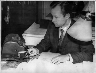 Retro photo of a young scientist making calculations on an adding machine. USSR, 50s of the...