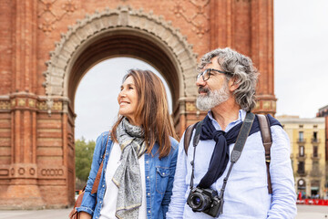 Mature married couple enjoying vacation visiting european city. Senior tourist walking in Barcelona...