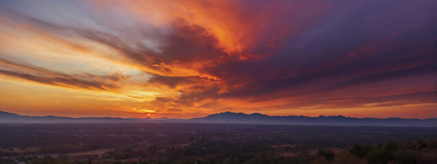 Captivating sunset sky in watercolor, dynamic blend of orange and purple hues.