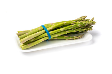 a bunch of fresh asparagus spears in a grocery store plastic tray isolated on white