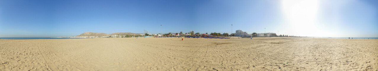 Wide panoramic photo taken in Agadir in Morocco showing the beach front and the mountains with the monument in the hill known locally as Dieu la Patrie Le Roi