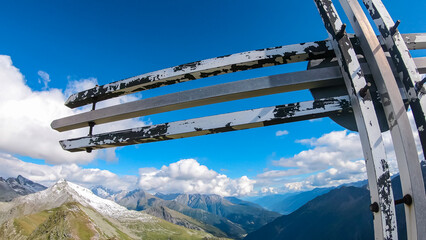Summit cross Greilkopf with scenic view of majestic mountain peaks of Glocker group, High Tauern...
