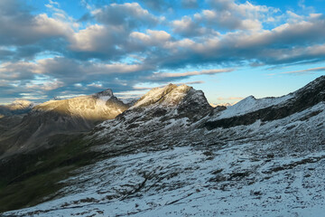 Panoramic sunrise view of snow capped alpine terrain in High Tauern National Park, Carinthia, Austria. Looking at majestic Gamskalrspitz seen from Hannoverhaus. Wanderlust Austrian Alps. Nature escape