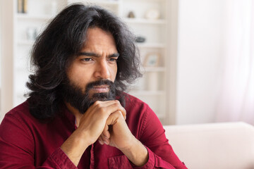 Man pondering in a well-lit room at home