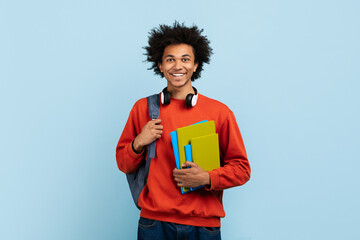 Student with headphones and notebooks