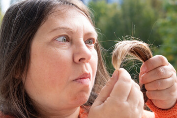 Examining role of hair inspection self-care routine and impact on self-image, mature woman examines...