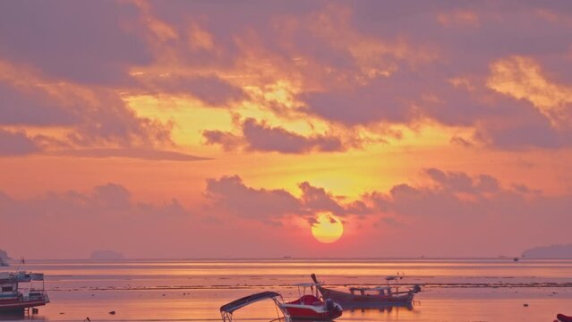 The beautiful sunrise above the fishing boats was accompanied by the beautiful sight of clouds in the beautiful sky
I could see the big, bright sun rising over the horizon in the distance.
