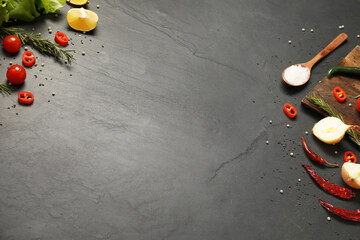 Cooking concept. Wooden cutting board and different products on black table. Space for text