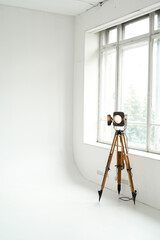 Retro cinema spotlight on a tripod in a photo studio on a white background. Vertical photo