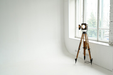 Retro cinema spotlight on a tripod in a photo studio on a white background. Horizontal photo