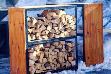 Chopped dry firewood on the shelves in the woodshed