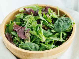 Fresh variety of salad greens in brown bowl