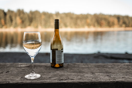 
glass of wine and a beautiful countryside lake view 