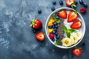 Healthy vegan breakfast bowl with chia pudding fruits and coconut milk on blue stone table Overhead view