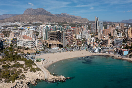 Aerial drone photo of the town of Benidorm in Spain in the summer time showing the beach known locally as Playa de Finestrat and hotels and apartments around the small beach
