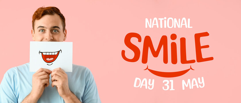 Young man with paper smile on pink background, closeup