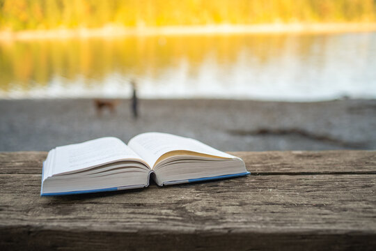 Open book closeup in a relaxing nature lake setting , reading relaxing concept 