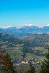Fototapeta na wymiar Panoramic view of alpine village St Lambrecht and snow capped mountain ridges Woelzer Tauern seen from mountain peek Grebenzen, Gurktal Alps, Styria, Austria. Calm serene atmosphere in Austrian Alps