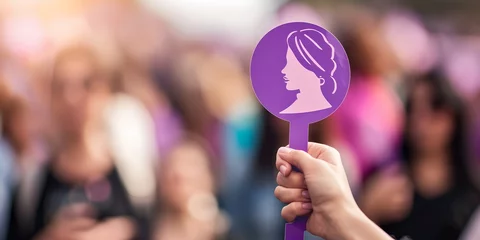 Fotobehang A woman holding a purple sign that says "I am a woman" © inspiretta
