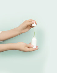 woman applying serum, lotion to her face