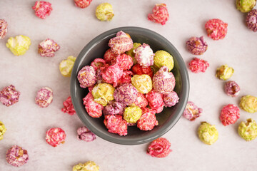Bowl with sweet colorful popcorn on white background