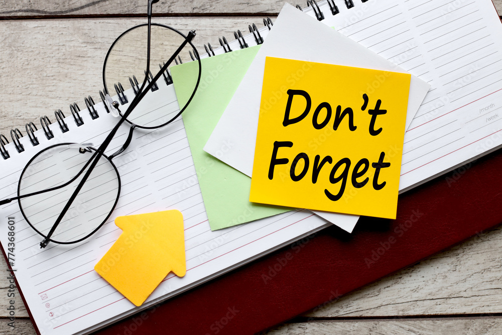 Poster do not forget text on a yellow sticky note on a diary