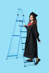 African-American female graduate student climbing stepladder on blue background