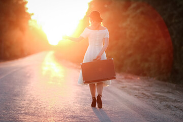 girl with a suitcase hitchhiking