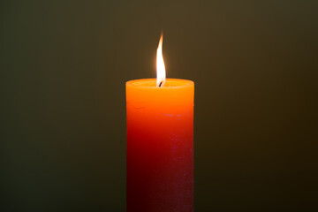 Candle light with flame on dark soft background