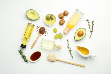Fototapeta na wymiar Vegetable fats. Different oils in glass bottles and ingredients on white table, flat lay