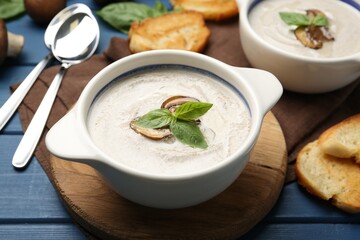 Fresh homemade mushroom soup served on blue wooden table