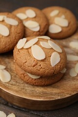 Cookies with fresh almond flakes on wooden table, closeup