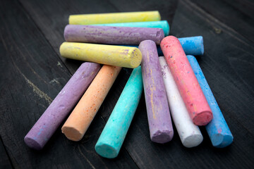 For children, colorful pieces of chalk on a wooden texture background