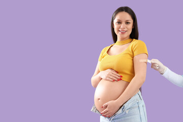 Young pregnant woman receiving medical patch after vaccination on lilac background