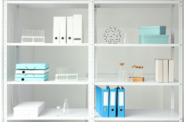 Shelf unit with chemistry tubes, flasks and folders in laboratory